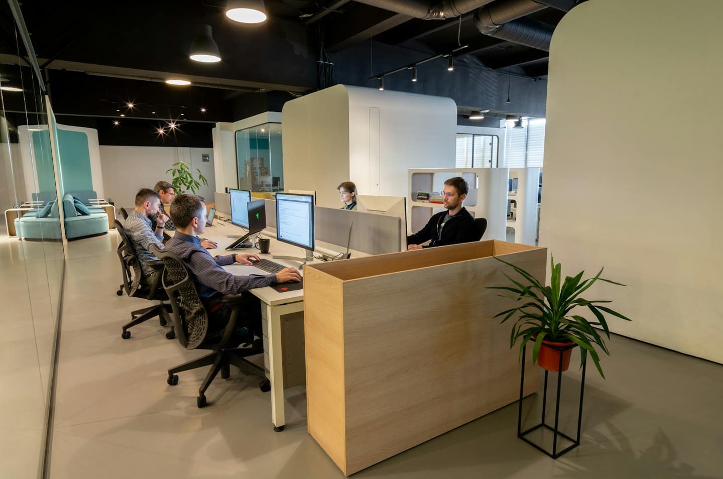 Professionaalid töötavad usinalt arvutite taga kaasaegses kontoris.